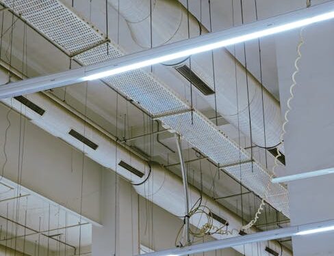 High-angle view of industrial ceiling showing exposed ducts and modern lighting.